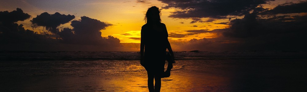 woman walking to sunrise
